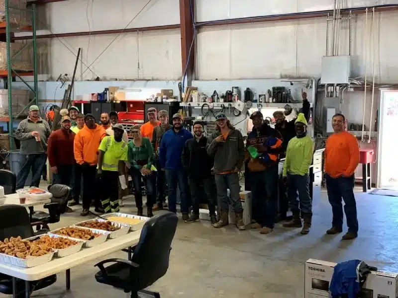 Team standing inside maintenance shop with equipment